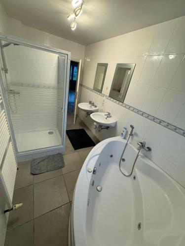a bathroom with a tub and a sink and a shower at Green escape - Sunset & nature in Boevange-sur-Attert