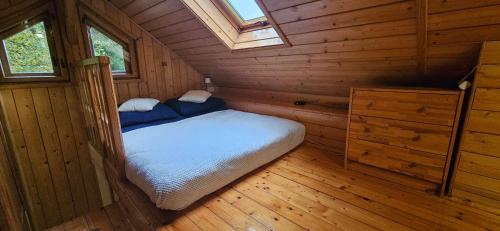 a bedroom in a wooden cabin with a bed at Mój Domek z kominkiem i jacuzzi na wyłączność in Wisła