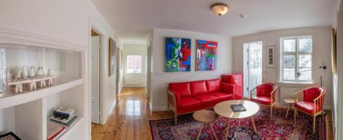 sala de estar con sofá rojo y sillas rojas en LL Properties - The Old Town Retreat, en Akureyri