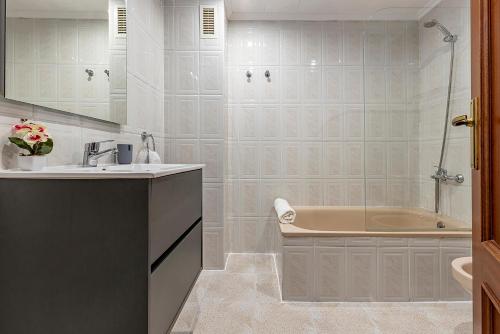 un baño con lavabo y bañera en Aimar Atico duplex Playa la Pineda Port Aventura, en La Pineda