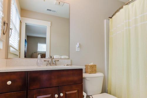 a bathroom with a sink and a toilet and a mirror at 412A The Inlet House in Virginia Beach