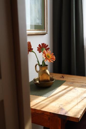 una mesa con un jarrón con flores. en Apartment Wörer, en Perca