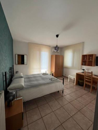 a bedroom with a large bed and a desk at B&B Pokerdassi in Leonforte