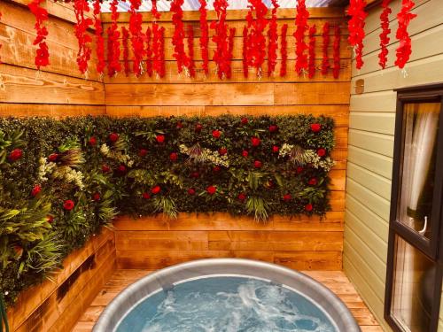 a wall with a garden of flowers and a tub at Little Eden Country Park, Bridlington with Private Hot Tubs in Bridlington
