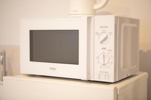 un horno microondas en la parte superior de un estante en 2025年10月リニューアル! SLEEPLAB駒込-Komagome-, en Tokio