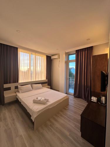 a bedroom with a bed and a large window at Wonderland in Chakvi