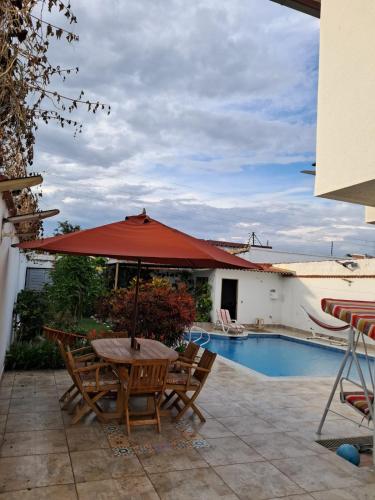 a table with an umbrella next to a swimming pool at Anapoima -Liberia in Anapoima