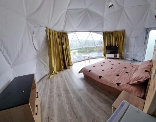 a bedroom with a large bed in a tent at GlampingDenis Igloo in Mihăeşti