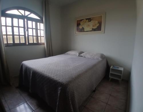 a bedroom with a bed and a window at Nossa Casa com Piscina in Guarapari