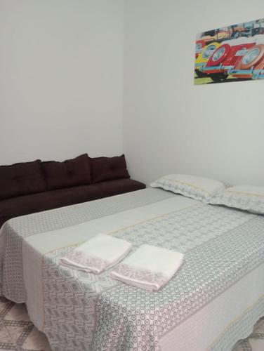 a bed with two white towels on top of it at Varanda palmeiras in Cabo Frio