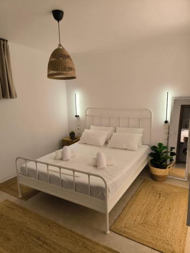 een slaapkamer met een wit bed en kussens bij Simple Home in Kardítsa