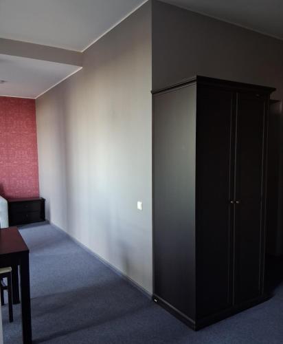a room with a black cabinet in a room with a bed at Šiluvos Svaja in Šiluva