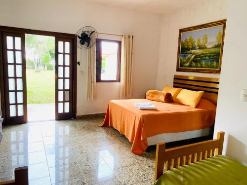 a bedroom with a bed and a window and a door at Pousada Maria Laura in Guararema