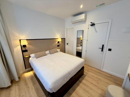 a bedroom with a large white bed and a mirror at Mucho Madrid in Madrid