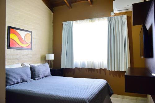 a bedroom with a bed and a large window at Complejo Pircas Mar in Las Grutas