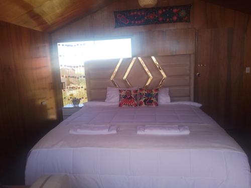 a bedroom with a large white bed with two pillows at Uros encantos del titikaka lodge in Puno
