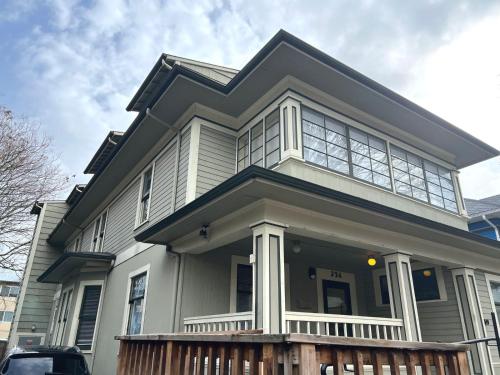a white house with a black roof at 376 Eugene Guest Rooms in Eugene