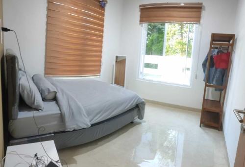Un dormitorio con una cama y una ventana con persianas. en Roemah Gebyok Taraman, en Ngemplak