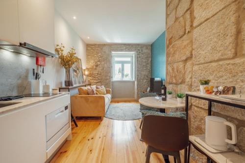a kitchen and living room with a table and a couch at Oporto Pool Apartment by Vacationy in Porto