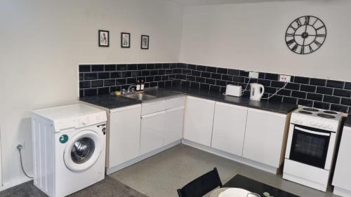 a kitchen with a sink and a washing machine at Comfy Stays Newcastle in Newcastle upon Tyne