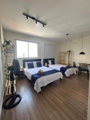 a room with three beds in a room with a tv at Ap Smart Hub Agro in Piracicaba