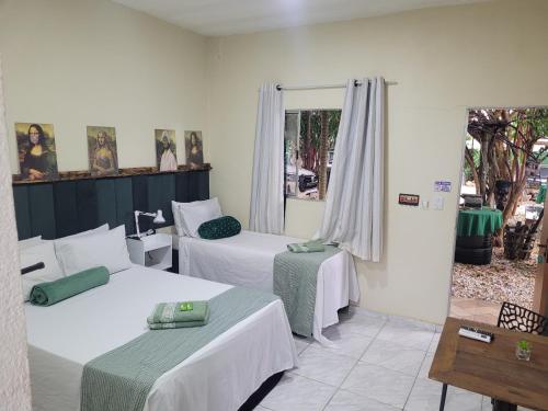 ein Hotelzimmer mit zwei Betten und einem Fenster in der Unterkunft Casa Verde in Cordisburgo