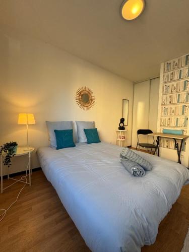 a large white bed in a room with a lamp at Néolia - Climatisé - Parking - Aix-Le Tholonet in La Celle-sous-Gouzon