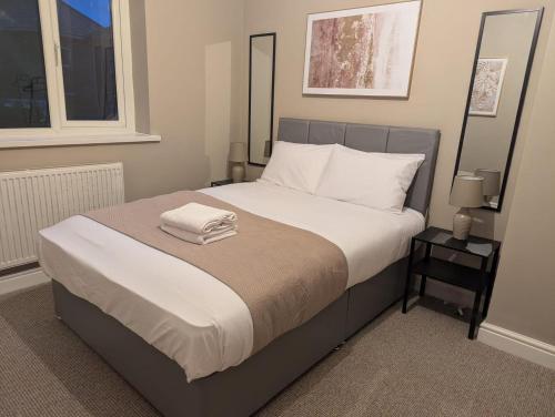 a bedroom with a large bed with two towels on it at Comfy Stays Newcastle in Newcastle upon Tyne
