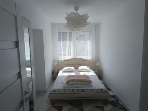 a small bedroom with a bed and a window at 2-room apartment, central & quiet in Gdynia