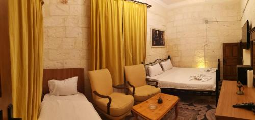 a room with two beds and a table and chairs at Emka historic biutuque stone house in Urfa