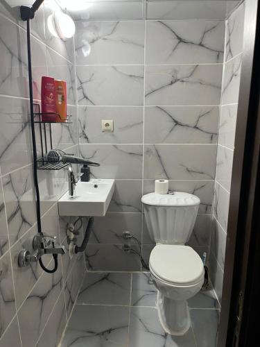 a white bathroom with a toilet and a sink at Emka historic biutuque stone house in Urfa
