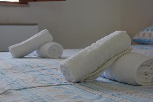 three rolls of towels on top of a bed at Adriatic Suite - Casa vacanze nel Salento in SantʼAndrea