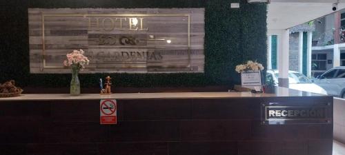 a hotel reception counter with flowers in a building at Hotel Las Gardenias in Cataltzul