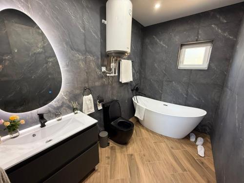 ein Badezimmer mit Badewanne, Waschbecken und Spiegel in der Unterkunft Agropensiunea TreiFrati 