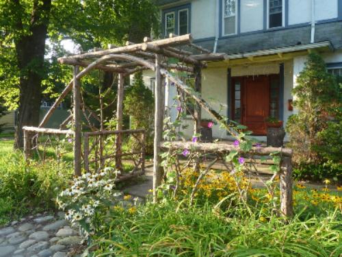 a house with a wooden pergola in front of it at Morning Glory B n B Woodstock NY in Woodstock