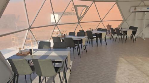 a group of tables and chairs in a large room at Bubbles Domes Private Cmp in Al Wāşil