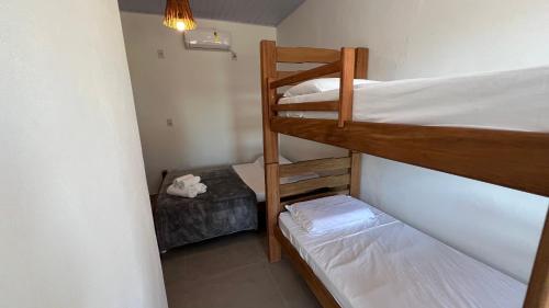 a small room with two bunk beds and a bed at Pousada Tamikuã in Caraíva