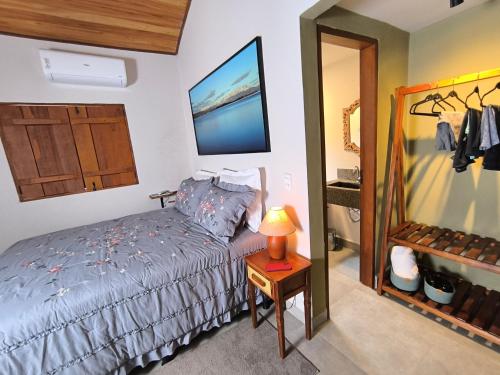 ein Schlafzimmer mit einem Bett und einer Lampe auf einem Tisch in der Unterkunft Loft do Fotógrafo 1 - Ao lado do Rio das Almas in Pirenópolis