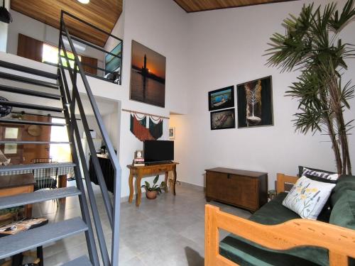 ein Wohnzimmer mit einer Wendeltreppe und einem Wohnzimmer in der Unterkunft Loft do Fotógrafo 1 - Ao lado do Rio das Almas in Pirenópolis