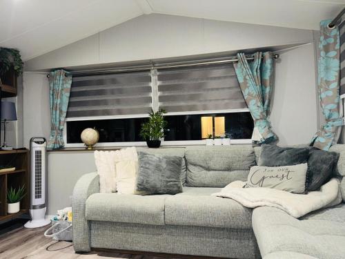 a living room with a couch and a window at Vinchella-3 bedroom caravan in Grange Over Sands