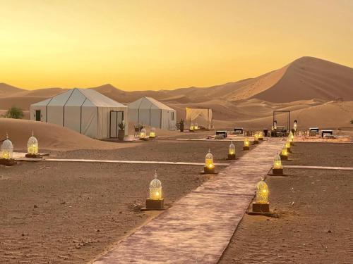 Una hilera de luces en el desierto con tiendas de campaña. en Merzouga Spirit Luxury Camp, en Merzouga