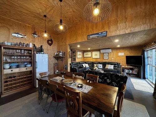 a kitchen and dining room with a table and a couch at Motutangi Heights in Pukenui