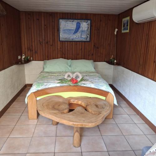 una camera da letto con un letto con una parete in legno di Au bord de l'eau sur Vairao Teahupoo a Vairao