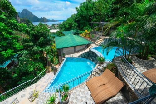an overhead view of a swimming pool with chairs and trees at El Nido Viewdeck Cottages in El Nido