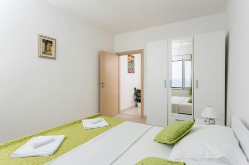 um quarto branco com uma cama e um espelho em Apartment Ivy em Dubrovnik