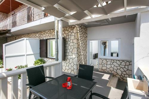 um pátio com uma mesa e cadeiras em uma varanda em Apartment Ivy em Dubrovnik
