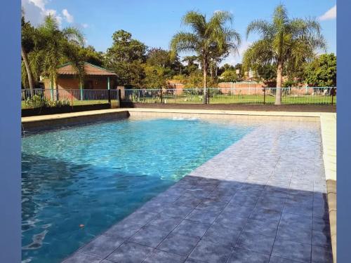 a large swimming pool with blue water at Mi Buen Refugio in Puerto Iguazú