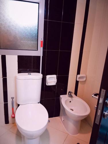 a bathroom with a white toilet and a sink at Eleganza House in Abu Dhabi