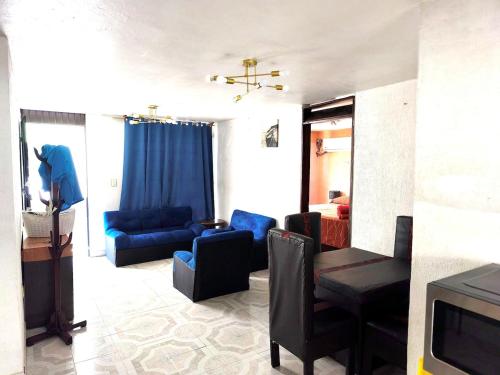 a living room with blue couches and a television at Departamento independiente en Playa sol in Coatzacoalcos