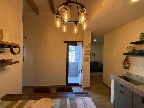 a kitchen with a chandelier and a hallway with a door at Solange Suite en ValQuirico in Santeagueda